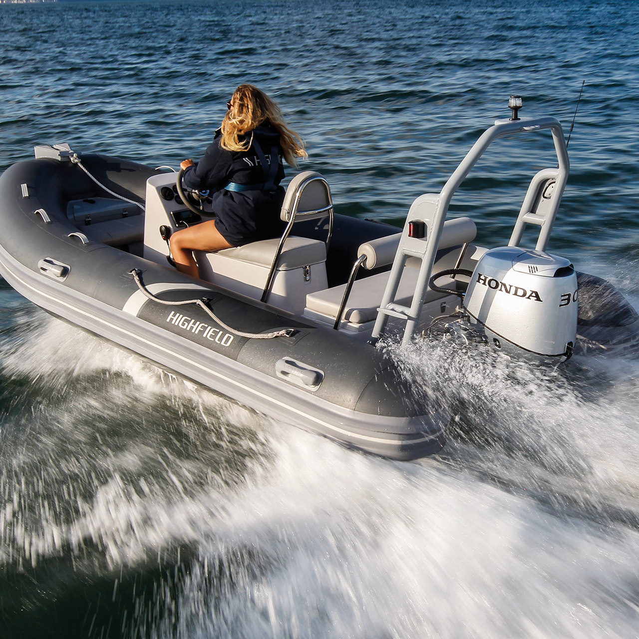 Lady on a highfield boat with a Honda BF30 engine in ocean location.