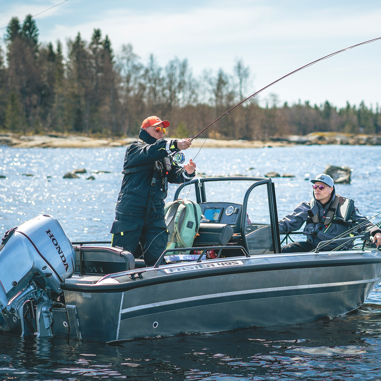 Gentlmen fishing from a boat with Honda BF30 engine in lake location.