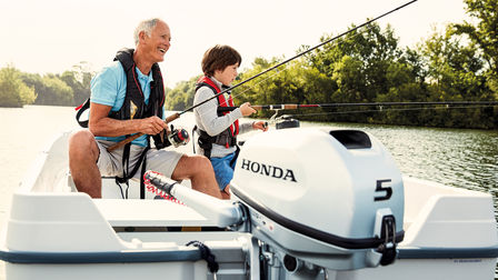 rear angled of family fishing on boat fitted with honda 5 horsepower outboard engine