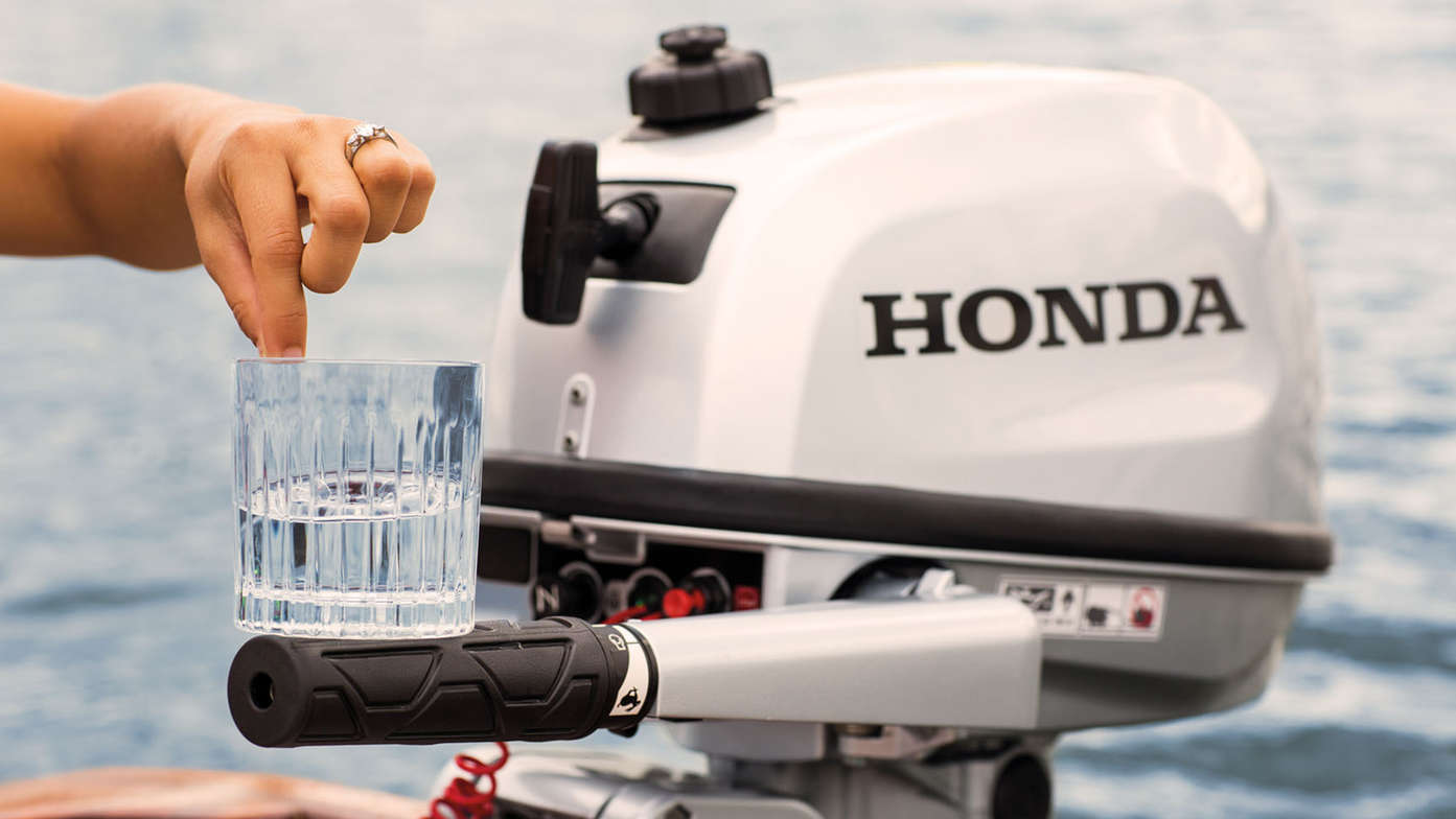 photo of glass of water balancing on honda marine engine's tiller handle to demonstrate low vibrations