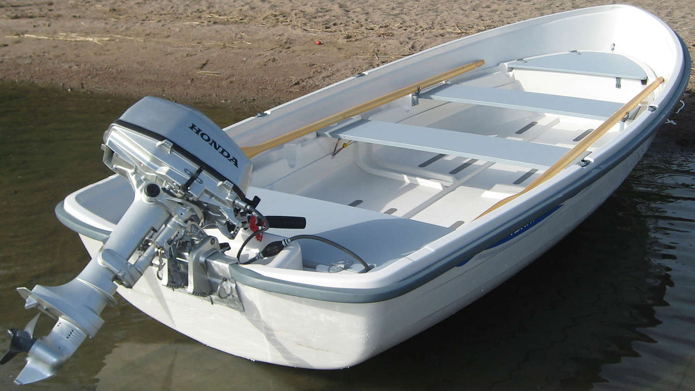 rear angled view of boat parked on beach fitted with a honda marine motor