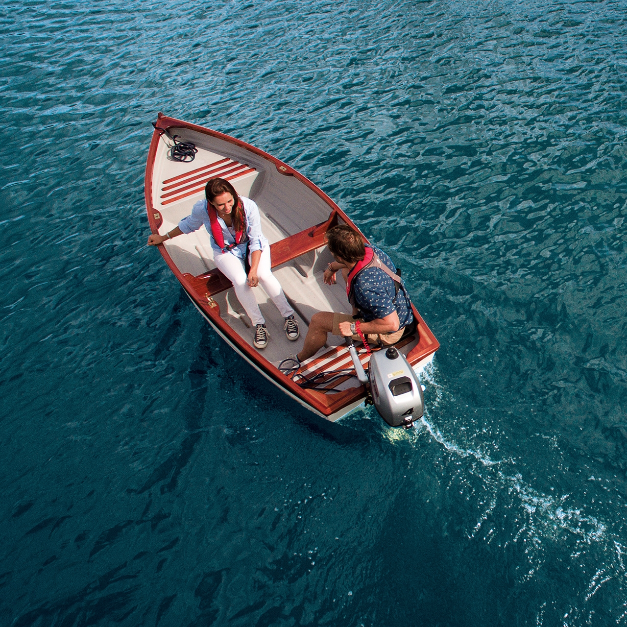 Couple on a boat with Honda engine in water location.