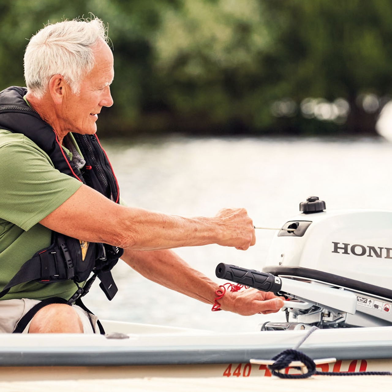 Gentleman on a boat starting a Honda BF5 engine.