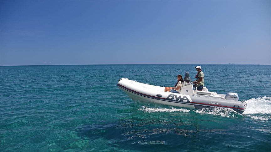 side view of couple on a boat powered by a honda marine engine