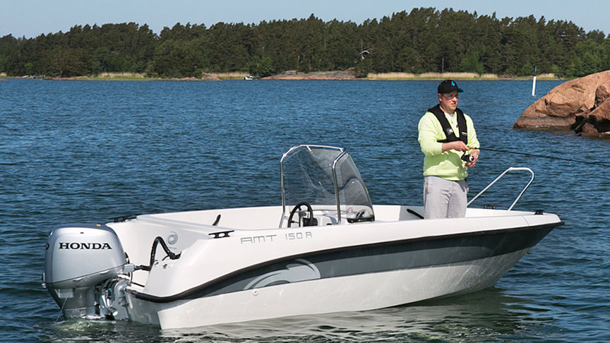 side angled view of man standing on boat fitted with a honda outboard motor