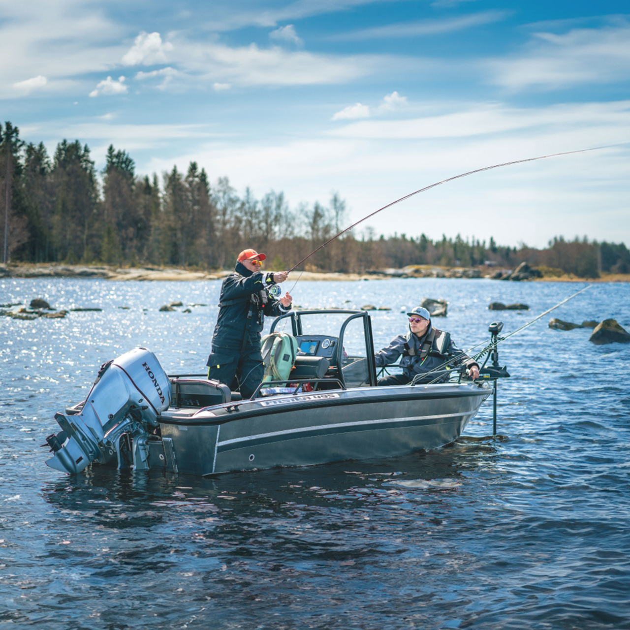 Two gentlemen fishing on a boat  with twin Honda BF60 engines in water location.