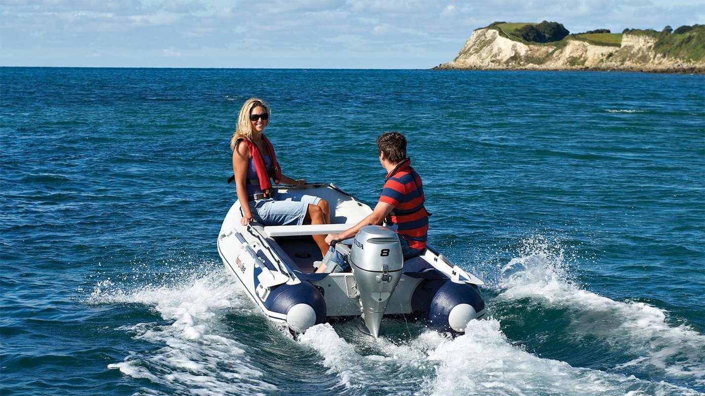 rear angled  of couple steering boat fitted with a honda marine outboard engine