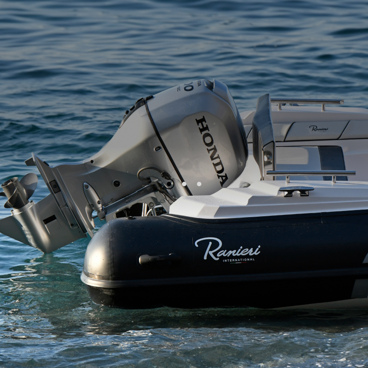 Close up of the Honda BF80-100 engine at the back of the boat in a sea location.