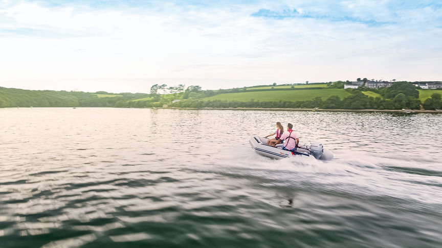 couple steering honwave inflatable boat on the water