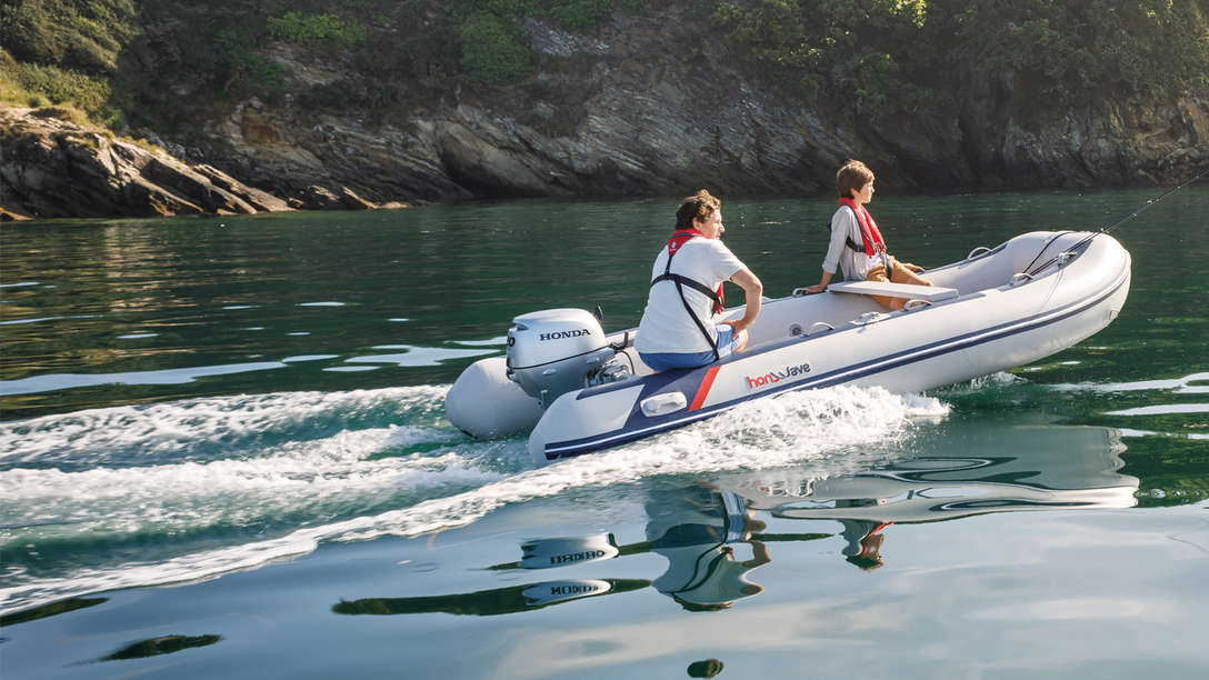 side view of a couple steering a honwave inflatable marine boat on the water
