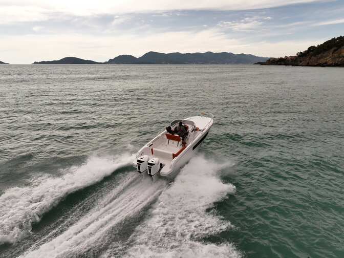Aerial view of boat steering through the sea.