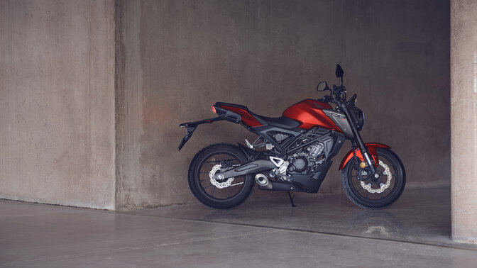 Honda Monkey on side stand in road with rider
