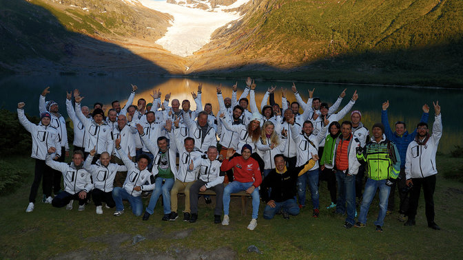 Honda Adventure Roads participants celebrating by the water at sunset.