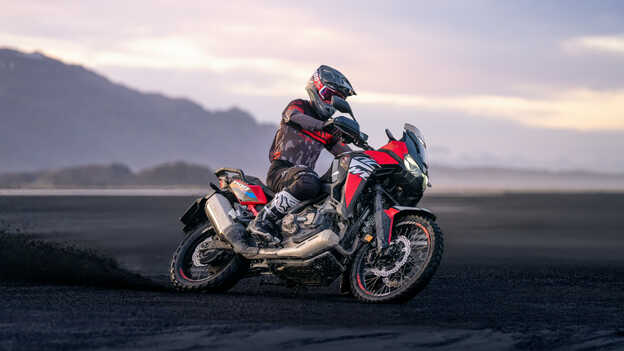 Front facing three quarter Honda Africa twin being ridden across the desert 