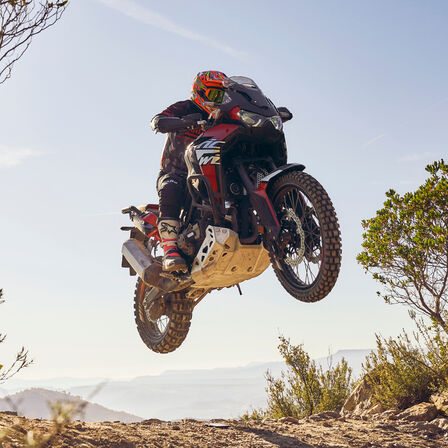 Rider on a Honda CRF1100L Africa Twin bike riding over rough terrain