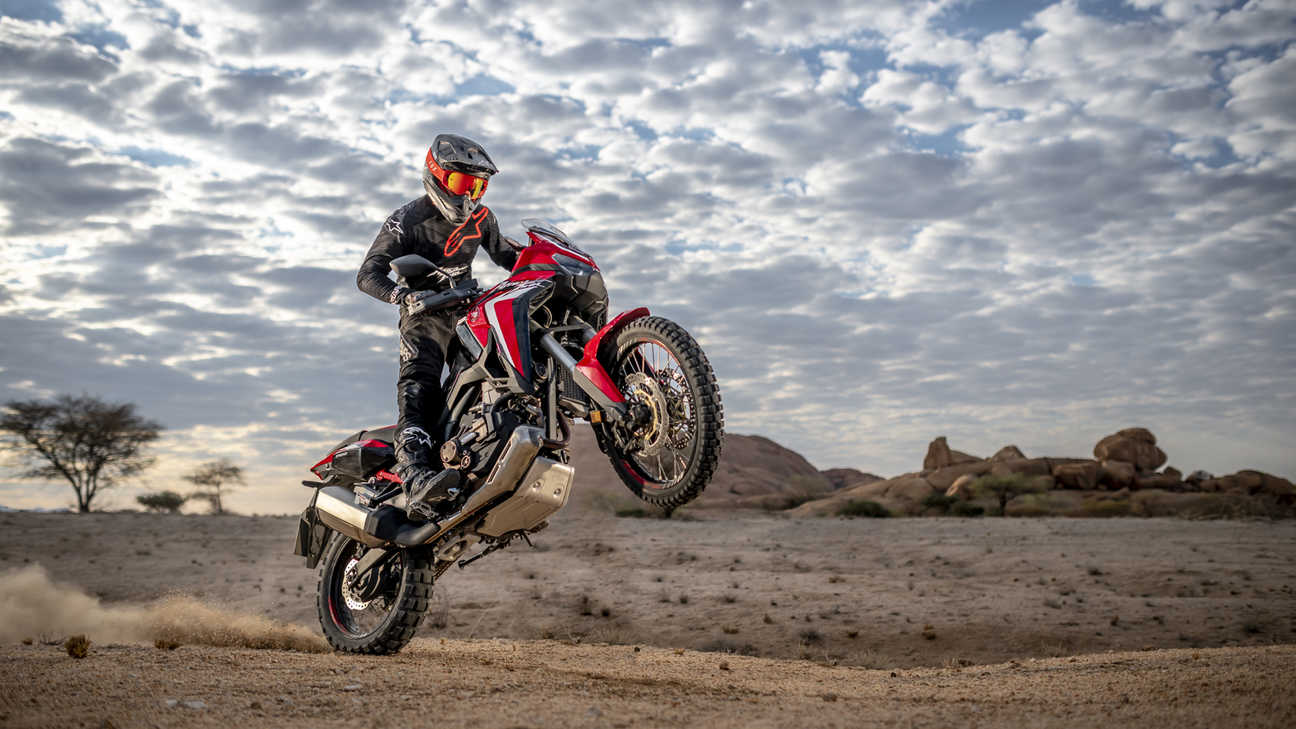 Honda Africa Twin, 3-quarter front right side, wheelieing in desert landscape
