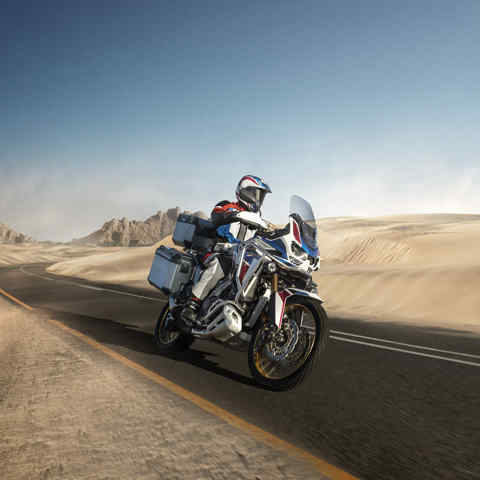 Honda Africa Twin Adventure Sports, 3-quarter front right side, riding on a road through a desert landscape