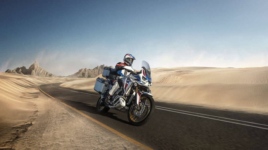 Honda Africa Twin Adventure Sports, 3-quarter front right side, riding on a road through a desert landscape