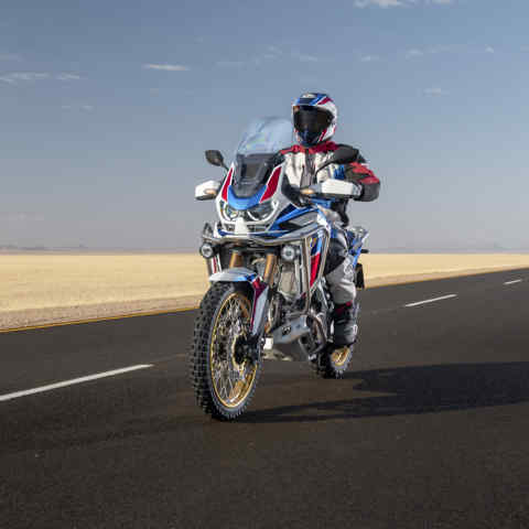Honda Africa Twin Adventure Sports, 3-quarter front left side, riding on a road through a desert landscape