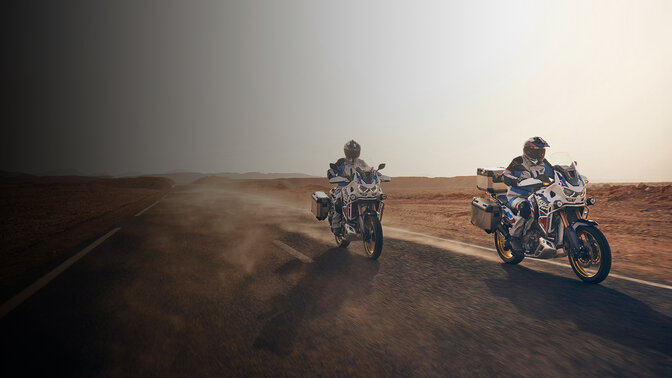 Front facing 3/4 riders on CRF1100 Africa Twin Adventure Sports on the road in desert. 