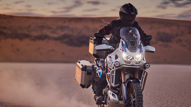 Rider on Honda CRF1100 Africa Twin Adventure Sports in desert location.