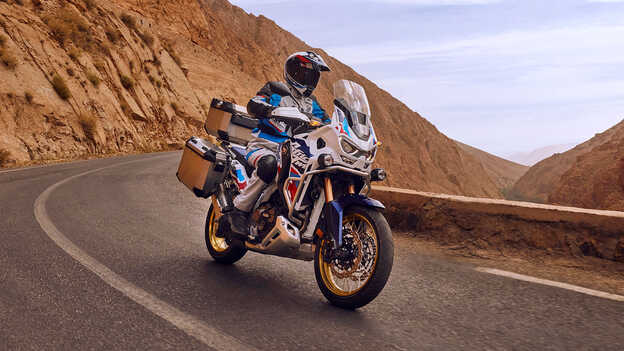 Rider on front facing Honda CRF1100 Africa Twin Adventure Sports in desert location.