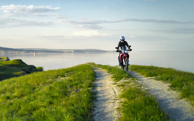 CRF250 Rally with rider on coastal road