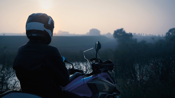 Rider sat on Honda NC750X, parked in rural location.