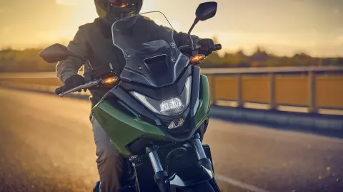 Front shot of a model riding the NC750X motorcycle on the road.