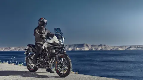 Honda NX500 static with rider next to coast