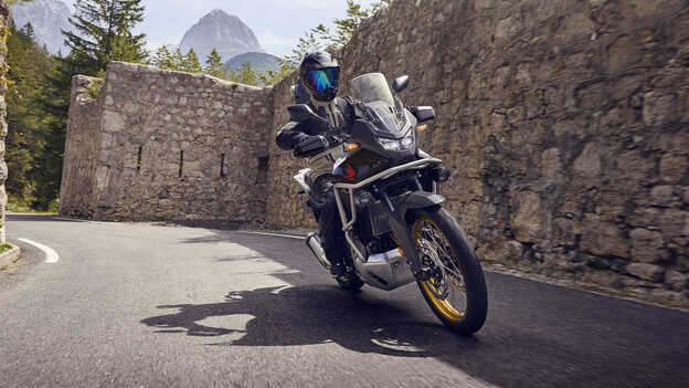 Rider driving a XL750 Transalp motorcycle in a city location.