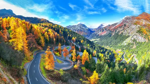 Stunning view of Maloja pass road at autumn time. Colorful autumn scene of Swiss Alps. Location: Maloya pass, Engadine region, Grisons canton, Switzerland, Europe