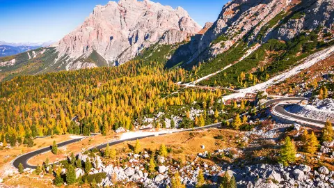 Passo Valparola, Italy. View of the serpentine in the Tyrol, Dolomite Alps. Mountain view Cima Cunturines (3.064 m) from Passo di Valparola with in autumn near Cortina d'Ampezzo, Belluno in Italy