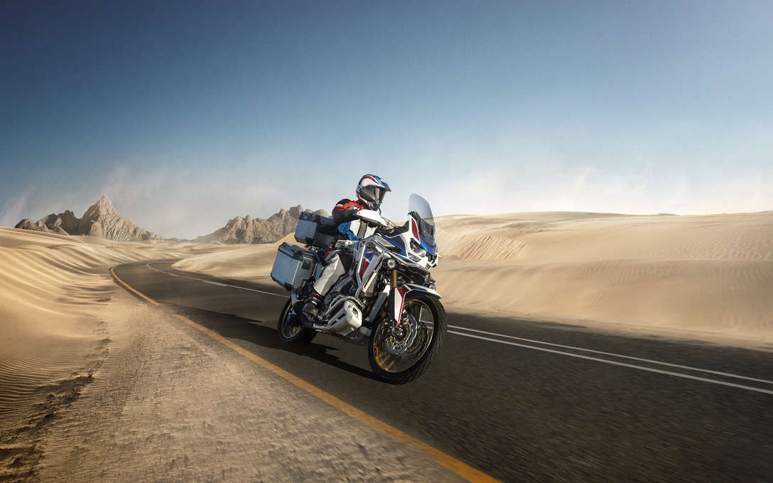 Honda Africa Twin Adventure Sports, 3-quarter front right side, riding on a road through a desert landscape