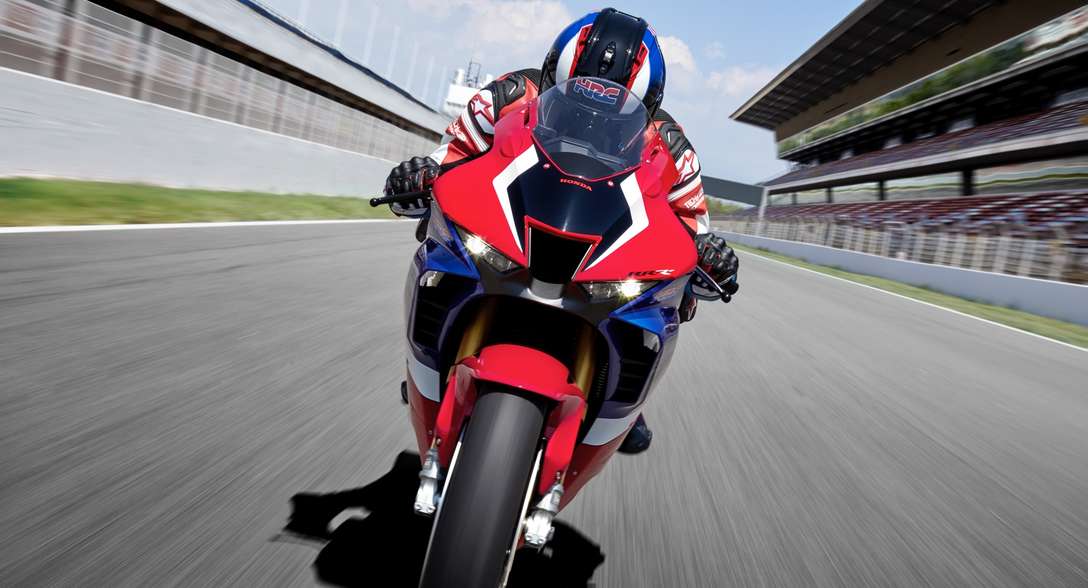 Honda CBR1000RR-R Fireblade SP, front face, with rider, riding on a racetrack