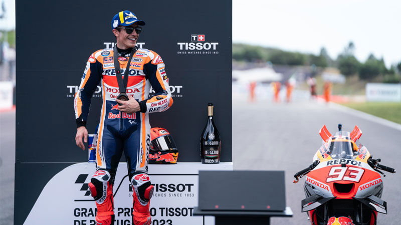 Marc Márquez stood next to race bike.