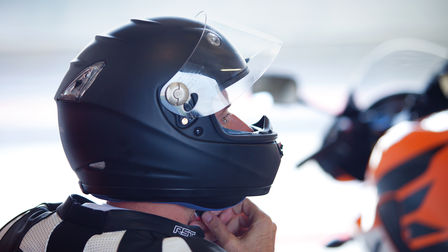 Rider adjusting his helmet.