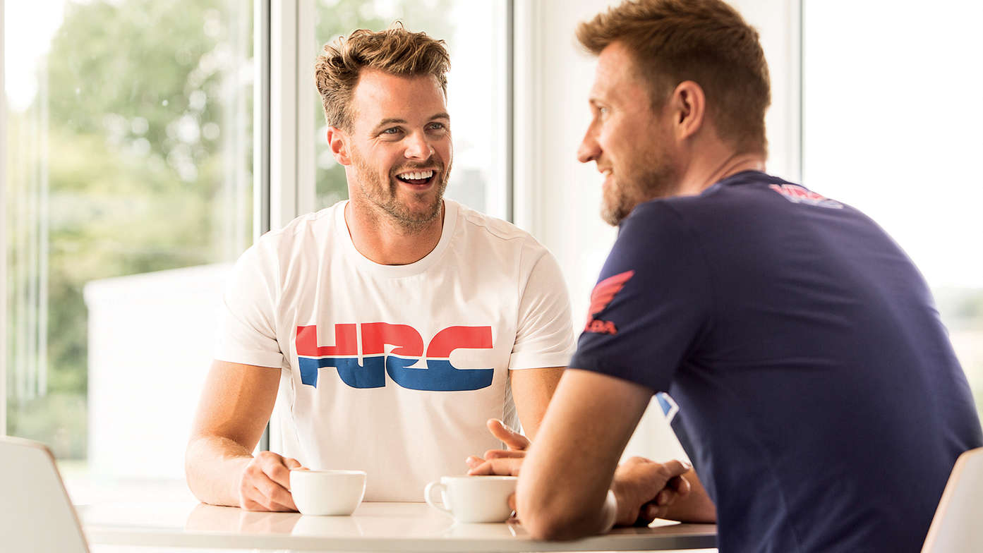 Two men smiling wearing white Honda shirts