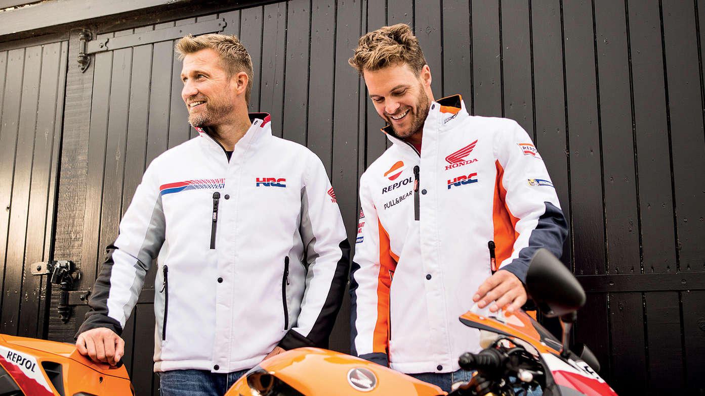Two men similing wearing white Honda race jackets