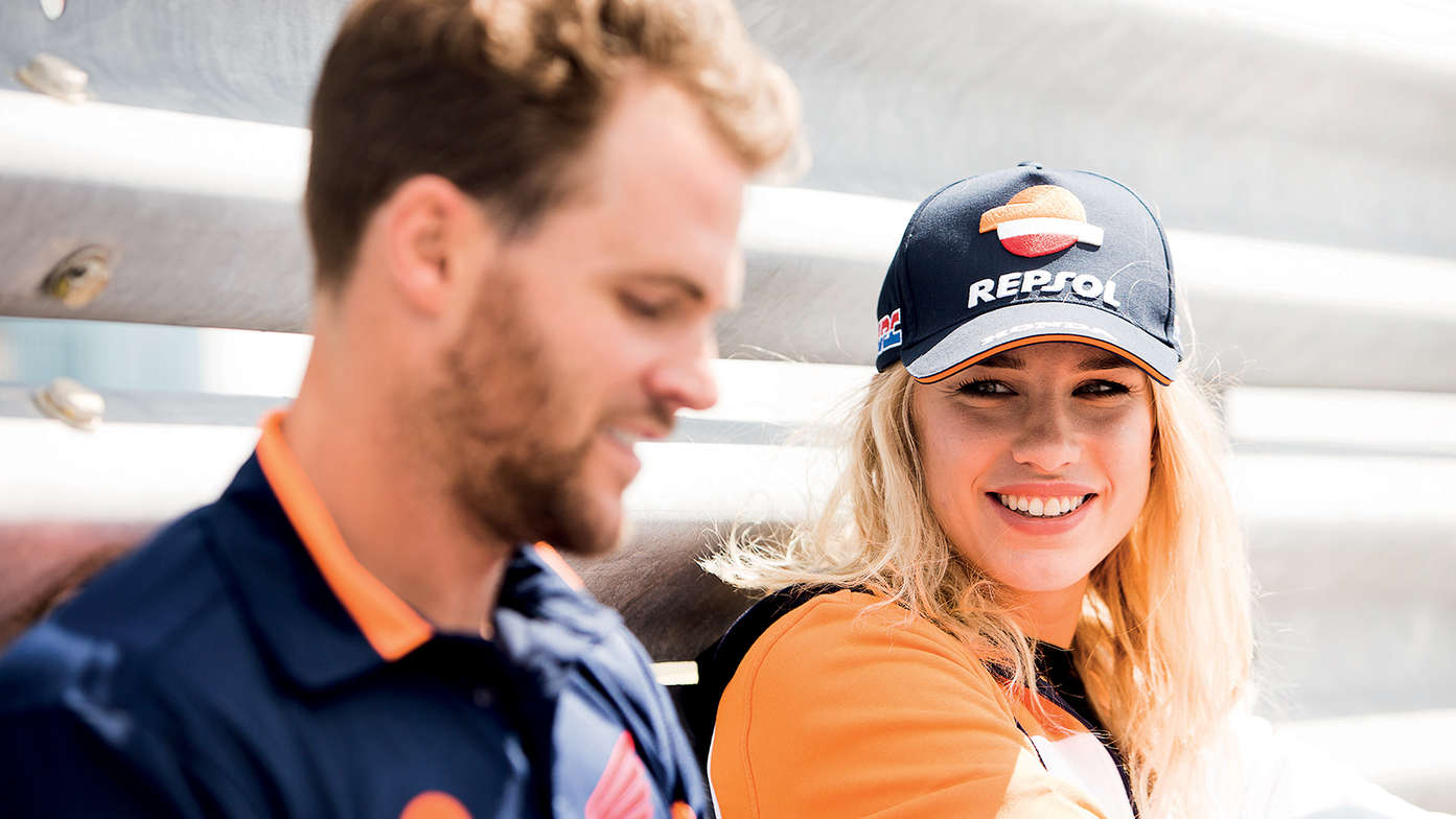 Woman wearing Honda cap smiling at the man.