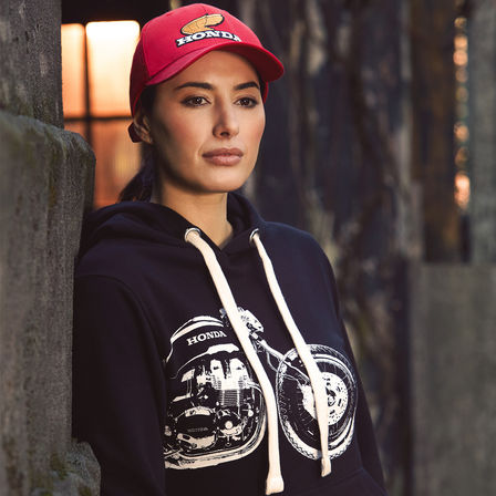Woman wearing vintage Honda hoodie and cap. 