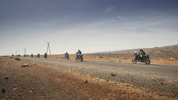Honda Africa Twin riders in Morocco on tarmac road.