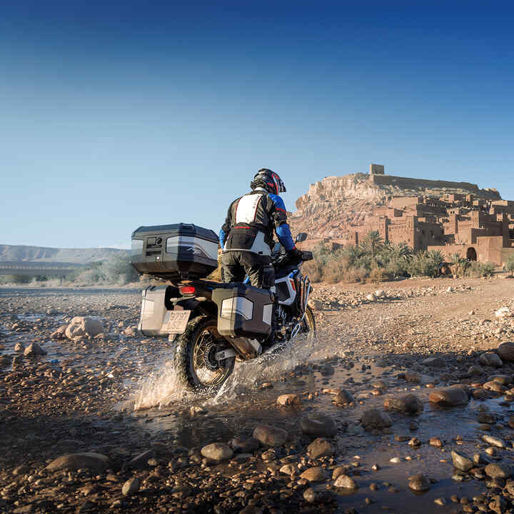 Rider on rear facing CRF1100 ATAS with touring accessories.