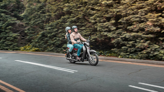 Honda Super Cub C125 on road with pillion