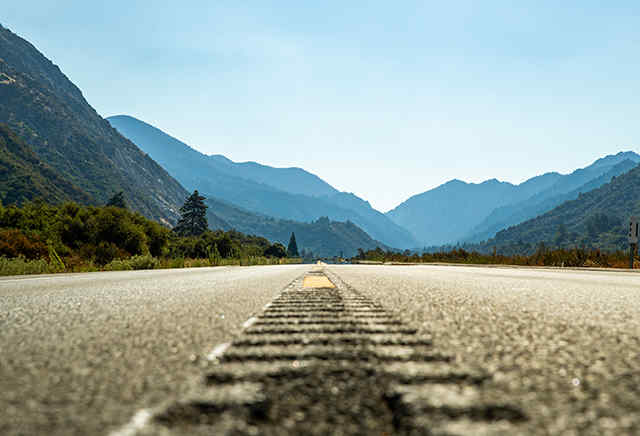 Open asphalt road leading out towards mountains