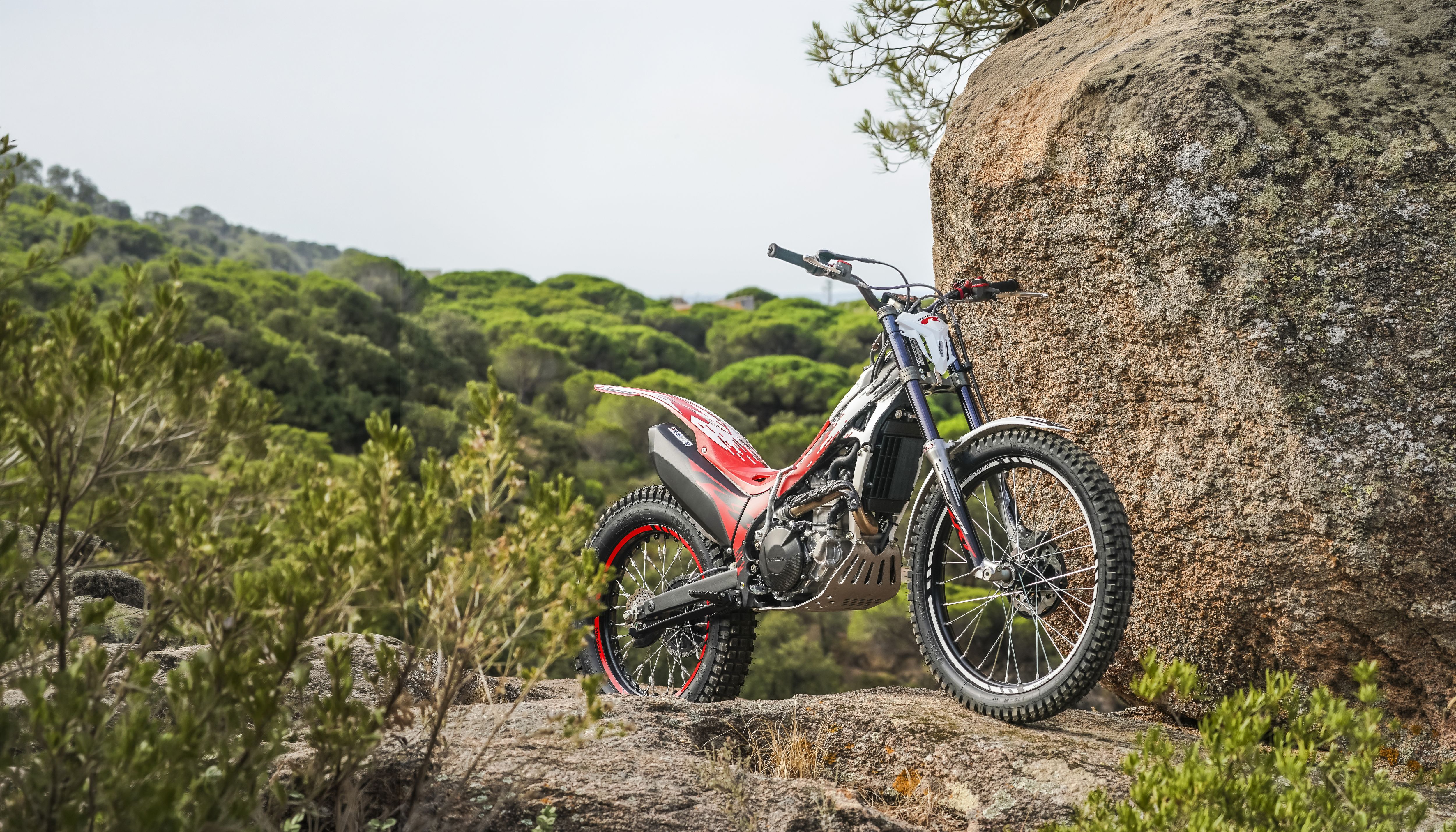 Montesa Cota 301RR trials bike standing on rocky terrain outdoors.