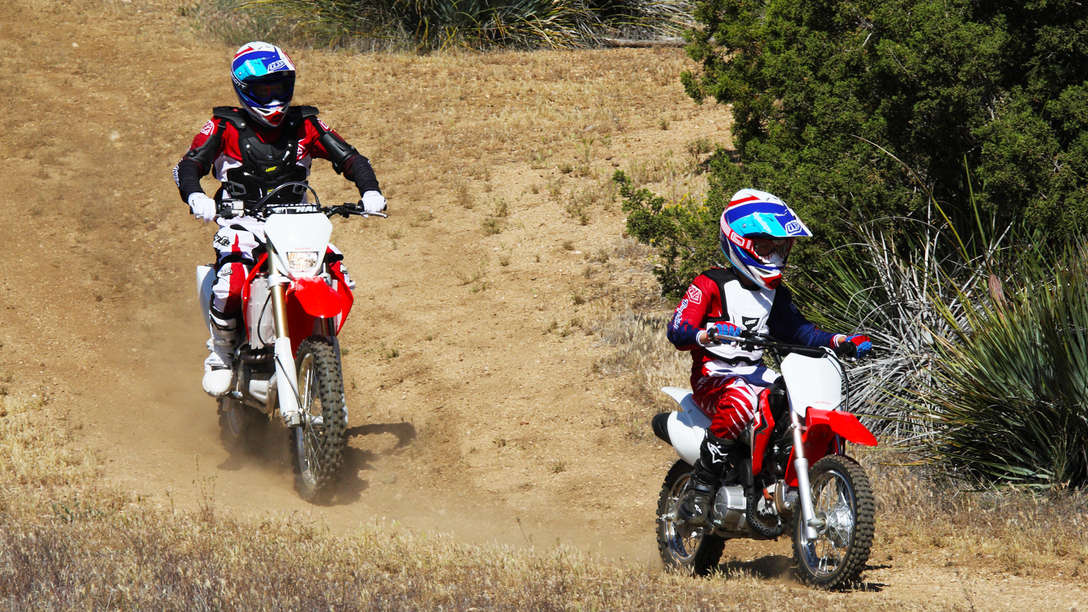 Side on, 3-quarter view of motorcycles with riders, race location, right facing.