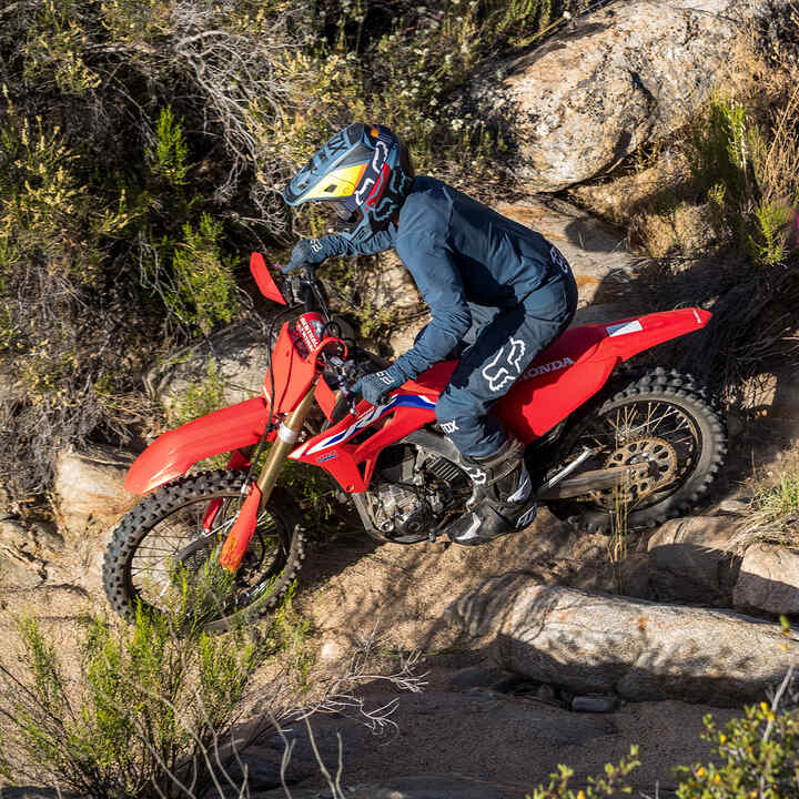 Honda CRF450RX being ridden over rocks.