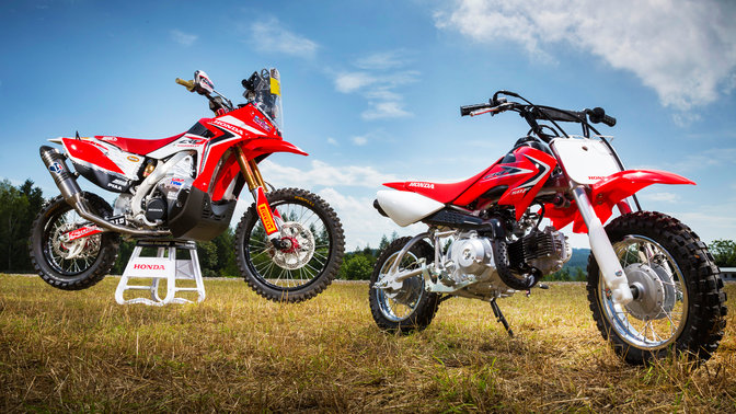 Side, three-quarter view of CRF50F, parked in field location. Right facing.