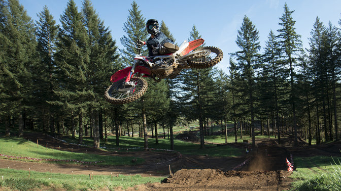 CRF450R jumping with rider. Dirt track location.